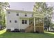The backyard shows a well-maintained lawn, classic siding, brick foundation and stairs leading to a covered porch at 301 Sawgrass Ct, Mebane, NC 27302