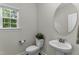 Powder room with pedestal sink and oval mirror at 301 Sawgrass Ct, Mebane, NC 27302