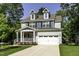 Inviting two-story home with dormers, covered porch, stone accents, and a spacious driveway at 301 Sawgrass Ct, Mebane, NC 27302