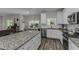 Well-lit kitchen features an island with granite countertops, white cabinets, and stainless steel appliances at 301 Sawgrass Ct, Mebane, NC 27302