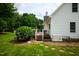 Well-maintained backyard with a deck, lush lawn, and a Generac generator next to the white-sided house at 3021 Glenwood Dr, Durham, NC 27705