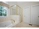 Bright bathroom features a soaking tub and a separate glass-enclosed shower at 3021 Glenwood Dr, Durham, NC 27705