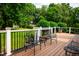 A view from the back deck to a well maintained green backyard with wrought iron patio furniture at 3021 Glenwood Dr, Durham, NC 27705