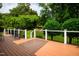 The back deck has brown stained boards, white rails, and a view of the lush backyard at 3021 Glenwood Dr, Durham, NC 27705