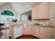 Bright kitchen with light wood cabinets, tile backsplash, and large arched window offering natural light at 3021 Glenwood Dr, Durham, NC 27705