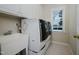Well-lit laundry room with modern washer and dryer, sink, and ample cabinet space at 3021 Glenwood Dr, Durham, NC 27705