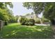 A well-maintained backyard featuring a lush lawn, mature trees, and a fenced perimeter at 304 Cayman Ave, Holly Springs, NC 27540