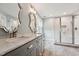 Modern bathroom featuring double sinks, marble countertop, and glass enclosed shower at 304 Cayman Ave, Holly Springs, NC 27540