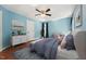 Serene bedroom with blue walls, hardwood floors, and a ceiling fan at 304 Cayman Ave, Holly Springs, NC 27540