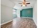 Spacious bedroom featuring a modern ceiling fan, wood floors, and fresh two-tone paint at 304 Cayman Ave, Holly Springs, NC 27540