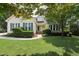 Charming home featuring manicured lawn, blue shutters, and lush landscaping at 304 Cayman Ave, Holly Springs, NC 27540