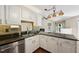 Kitchen island with granite countertops, white cabinets, and stainless steel dishwasher at 304 Cayman Ave, Holly Springs, NC 27540