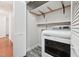 Laundry room featuring a modern dryer unit and wood shelving at 304 Cayman Ave, Holly Springs, NC 27540
