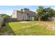 Large backyard featuring a wooden fence, grass, and a back entrance to the home at 304 Westfield Dr, Dunn, NC 28334