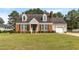 Charming brick home with a manicured front lawn, dormer windows, and attached garage at 304 Westfield Dr, Dunn, NC 28334