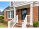 Inviting front porch with brick steps, white railings, and a charming entryway at 304 Westfield Dr, Dunn, NC 28334