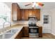 Well-equipped kitchen with dark cabinetry, stainless steel appliances, and a ceiling fan at 304 Westfield Dr, Dunn, NC 28334