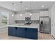 Modern kitchen with white cabinetry, stainless steel appliances, and a blue center island at 309 Highland Forest Dr, Fuquay Varina, NC 27526