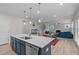 Open kitchen with island, stainless appliances, and seamless flow into dining and living areas at 309 Highland Forest Dr, Fuquay Varina, NC 27526