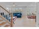 Bright living room with hardwood floors, large windows, and stylish blue sectional sofa at 309 Highland Forest Dr, Fuquay Varina, NC 27526