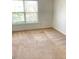 This bedroom boasts plush carpeting, neutral walls, and ample natural light from the nearby window at 3207 Geary Trl, Raleigh, NC 27610