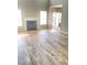 Spacious living area featuring a fireplace, windows, and laminate flooring bathed in natural light at 3207 Geary Trl, Raleigh, NC 27610