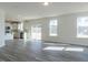 Open-concept living room featuring wood-look floors, bright windows and views of the kitchen at 417 Hipwood Dr, Zebulon, NC 27597