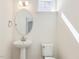 Clean half-bathroom featuring a pedestal sink, oval mirror, and a toilet at 425 Hipwood Dr, Zebulon, NC 27597