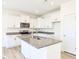 Bright kitchen featuring a large island with a sink, white cabinets, and granite countertops at 425 Hipwood Dr, Zebulon, NC 27597