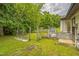 Fenced backyard with mature trees, a gate, and equipment at 428 Walton St, Durham, NC 27703