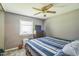 Bedroom featuring a ceiling fan, a window with blinds, and a dresser with a television on top at 428 Walton St, Durham, NC 27703