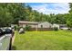 View of a single story home featuring a well manicured lawn with mature trees and an updated driveway at 428 Walton St, Durham, NC 27703