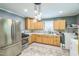 Updated kitchen featuring stainless steel appliances, light wood cabinets, and a unique lighting fixture at 428 Walton St, Durham, NC 27703