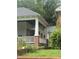 Bungalow front porch with columns, brick foundation, and overgrown front yard at 431 Charles St, Henderson, NC 27536