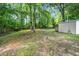 Lush backyard with mature trees, green grass and a storage shed at 518 Buck Branch Dr, Garner, NC 27529