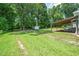 Expansive backyard featuring a covered patio, green lawn, storage shed, and mature trees at 518 Buck Branch Dr, Garner, NC 27529