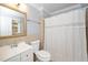 Bright bathroom with a vanity, mirror, toilet, and shower with a white curtain at 518 Buck Branch Dr, Garner, NC 27529