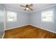 Cozy bedroom features hardwood floors, ceiling fan, and natural light from two windows at 518 Buck Branch Dr, Garner, NC 27529