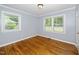 Bedroom with hardwood floors, light blue walls, and a window overlooking trees at 518 Buck Branch Dr, Garner, NC 27529