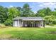 Rear exterior view showcasing a covered patio with stairs and lush green backyard at 518 Buck Branch Dr, Garner, NC 27529