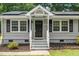 Close up of front porch with gray brick, black door, and white columns at 518 Buck Branch Dr, Garner, NC 27529