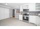 Bright kitchen featuring stainless steel appliances, white cabinets, and tiled floors at 518 Buck Branch Dr, Garner, NC 27529