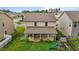 Aerial view of a backyard featuring a covered patio, lush lawn, privacy fence, and playful swing set at 542 Spaulding St, Burlington, NC 27215