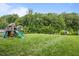 Large backyard with lush greenery, playground and shed, perfect for Gathering fun and storage at 542 Spaulding St, Burlington, NC 27215