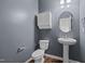 Powder room with toilet, sink, cabinet, round mirror and gray paint at 542 Spaulding St, Burlington, NC 27215
