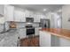 Kitchen featuring white cabinets, stainless appliances, granite countertops, and wood island at 542 Spaulding St, Burlington, NC 27215