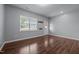 Well-lit living room with wood floors features a window and a white front door at 542 Spaulding St, Burlington, NC 27215