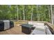 Enjoy this peaceful back deck with an outdoor seating area and lush tree coverage at 5550 Mountain Trl, Snow Camp, NC 27349