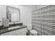 Clean bathroom with a vanity, gray countertops, toilet, and a shower with a black and white striped curtain at 5550 Mountain Trl, Snow Camp, NC 27349