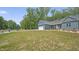 Beautiful blue home featuring a two-car garage, landscaped yard, and rocking chair front porch at 5550 Mountain Trl, Snow Camp, NC 27349